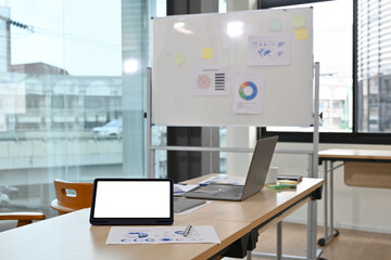 Empty screen of Tablet computer placed on a desk in a boardroom.