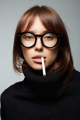 Obraz premium beautiful smoking woman in glasses. hooligan girl with cigarette