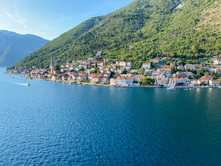 Naklejka premium Kotor, Montenegro - July 18, 2022: Shoreline buildings and cathedrals along the narrow fjord en route to Kotor, Montenegro 