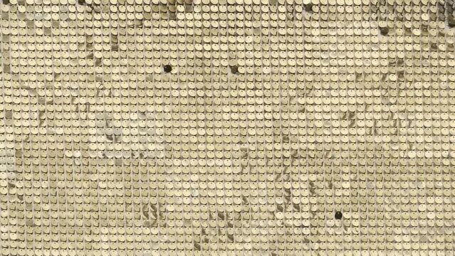 rows of blinking golden yellow brass metal plaques sway in wind and shines in sun and create unique pattern of movement. round reflective particles texture glitter under waves of wind. Spangle Glitter