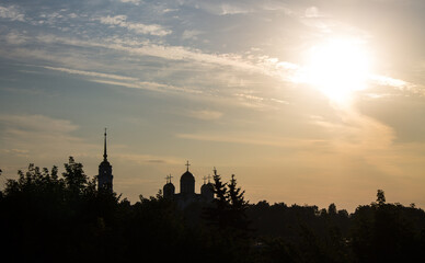 Dramatic urban landscape - the black silhouette of the Assumption Cathedral with a bell tower in Vladimir russia in the early summer morning at dawn blurred in a hazy haze
