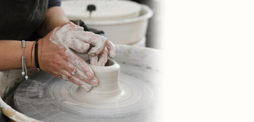 Banner Potter making bowl on wheel. self-employed pottery artist in creative studio working with raw clay shaping handmade cup or jar. Cheerful ceramics art teacher on master class lesson in workshop