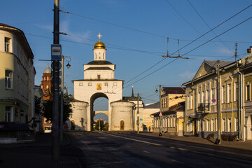 Fototapeta na wymiar Vladimir, Russia - August, 16, 2022: facade of the old white stone golden Gate in the historical center of the city on a sunny summer day