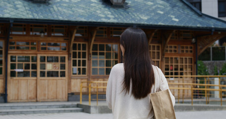 Fototapeta na wymiar Travel woman look at the wooden building in xinbeitou of Taiwan