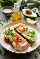 Sandwiches with salted salmon,  avocado and microgreens.