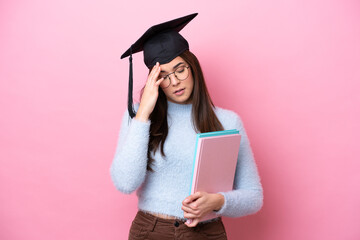 Young student Brazilian woman wearing graduated hat isolated on pink background with headache