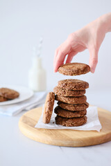 Woman's hand holding a cookie from a stack freshly baked