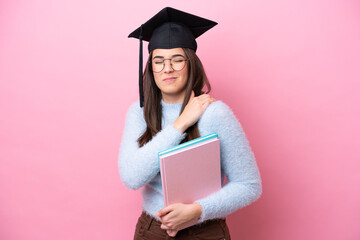 Young student Brazilian woman wearing graduated hat isolated on pink background suffering from pain in shoulder for having made an effort