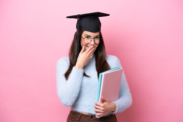 Young student Brazilian woman wearing graduated hat isolated on pink background happy and smiling covering mouth with hand