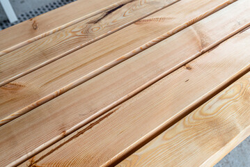 Raw planed pine wooden beams, dimensions 100x100mm, lying next to each other.