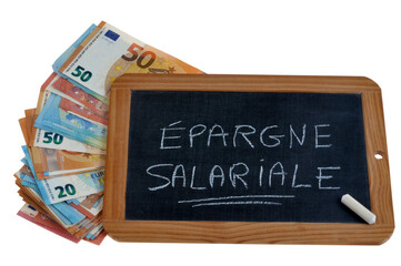 Ardoise d'école sur laquelle est écrit épargne salariale avec une craie et des billets de banque en euros sur fond blanc