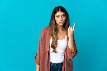 Fototapeta premium Young caucasian woman isolated on blue background intending to realizes the solution while lifting a finger up