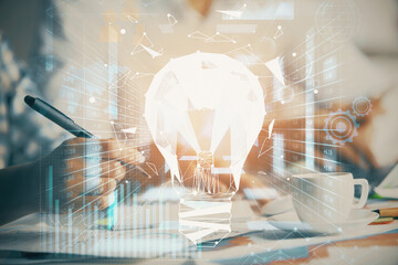 Double exposure of bulb drawing over people taking notes background. Concept of idea