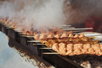 grilled meat on coals in a cafe in uzbekistan. barbecue on the grill in a tourist place. frying...