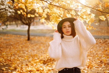 Stylish woman enjoying autumn weather in the park. Fashion, style concept.