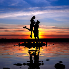 Naklejka na ściany i meble silhouette of a love couple on a sunset