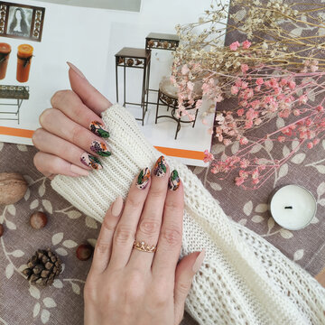 close-up of female hands with autumn manicure and accessories on the table