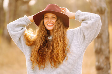 Stylish woman  in hat enjoying autumn weather in the park. Fashion, style concept.