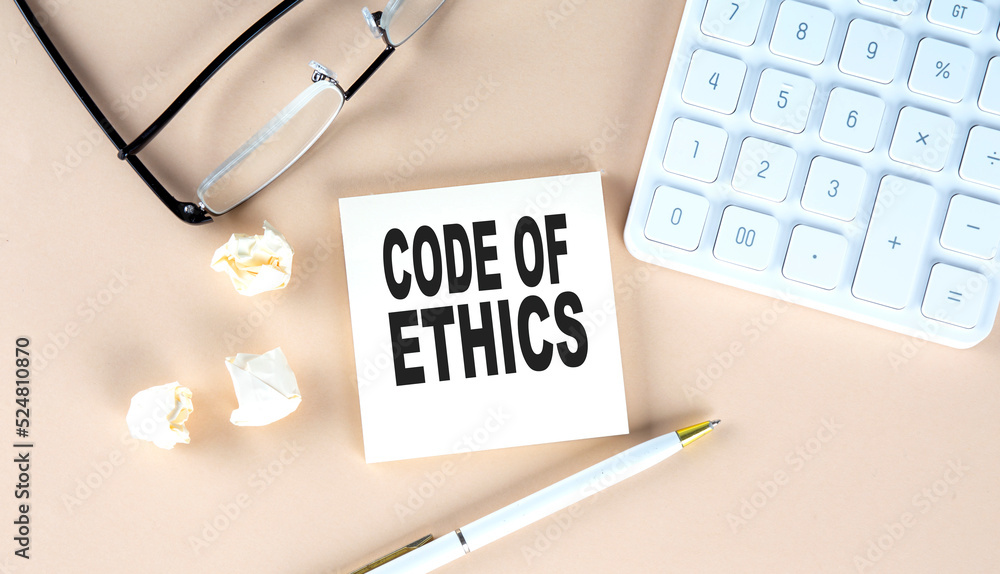 Poster code of ethics text on sticky with pen ,calculator and glasses on a beige background