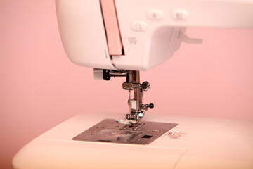 Composition from a sewing machine. Mannequin, flowers on a retro table and threads. Sewing supplies and composition with a sewing machine in the interior. With the letter M. for the fashion magazines