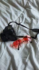 pink glasses on a white background.glasses on a white cravate.glasses and camera on a white background.camera on the bed.camera and glasses on a white background