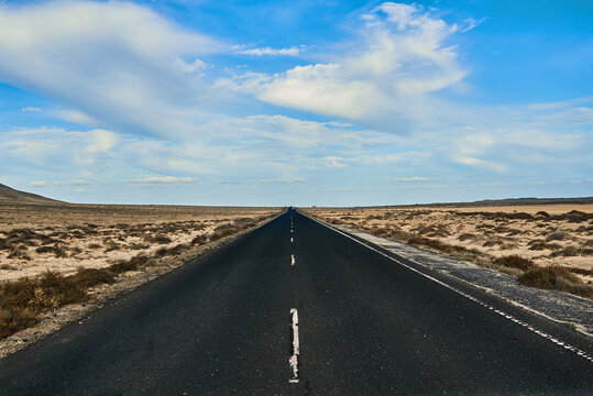 Empty asphalt road between desert with mount