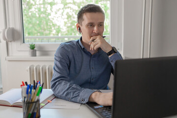 Naklejka premium Thoughtful businessman think of online project looking at laptop. Dreamy professional consider solution sit at work desk with computer. 