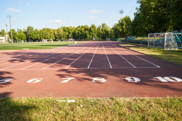 Running track. Red treadmill at the stadium with white lines.