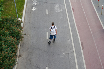 Man is inline skating on cycling road. Top aerial view.