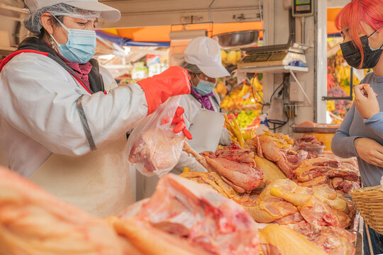 Peruvian sellers in masks selling chicken