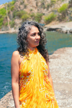 Contemplative ethnic traveler in pareo on pier against sea