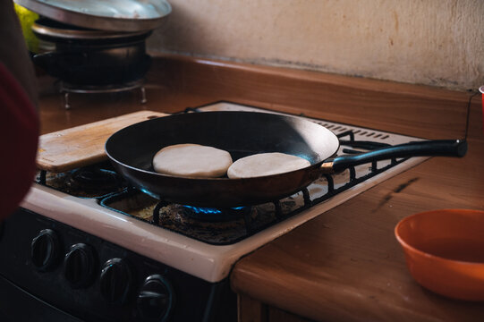 Arepas in frying pan on gas stove