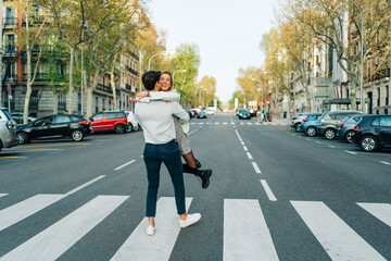 Cheerful couple having fun on road in city