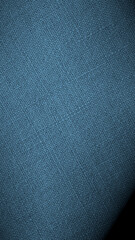 Blue woven surface closeup. Linen textile texture. Fabric handicraft background with vignetting. Textured braided backdrop. Len vertical phone wallpaper. Macro