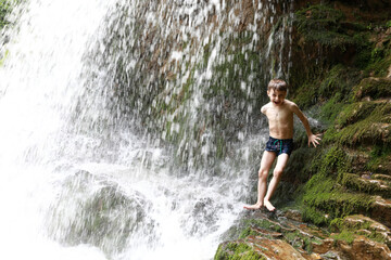 Child under waterfall Shum on Rufabgo stream