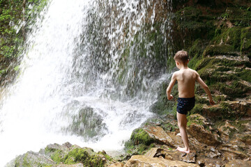 Child walking to waterfall Shum on rufabgo stream