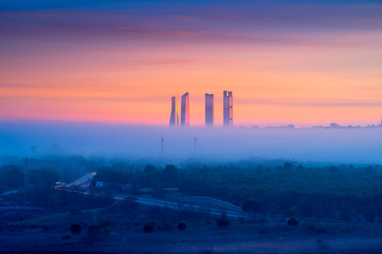 Skyscrapers over foggy city at dawn
