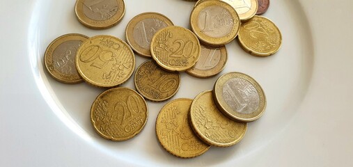 Euro coins on a white background. Money background. Euro currency in Europe. One euro, fifty cents, twenty cents and ten cents. Euro coins in a spoon.