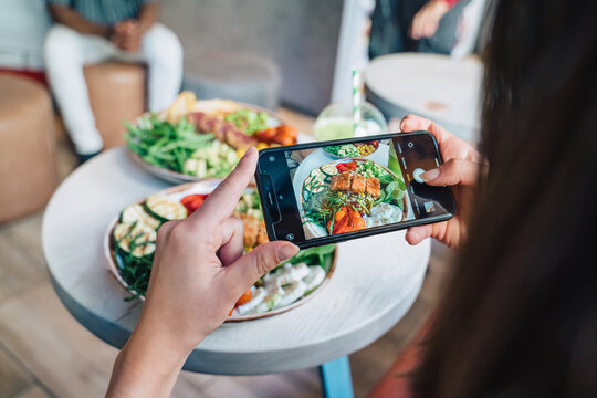 Crop blogger taking photo of healthy food on smartphone