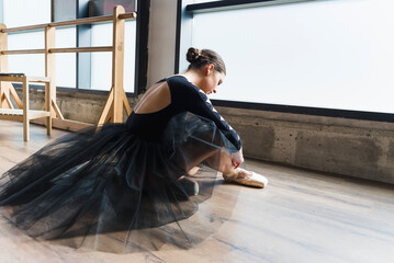 Young ballerina tying pointe shoes