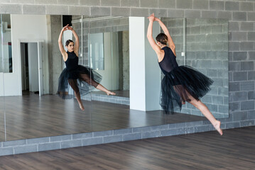 Young ballerina jumping at dance studio