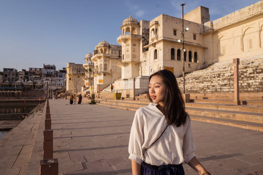 Asian tourist walking on sacred lake embankment