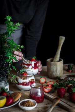 Chef cooking tasty dessert with fresh berries in dark kitchen