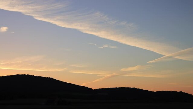 sunrise timelapse with mountains and red sky, illuminated clouds