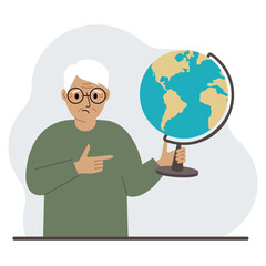 A old man holds a globe in his hand and points his finger at it. The concept of education, teacher, world conquest, ecology.