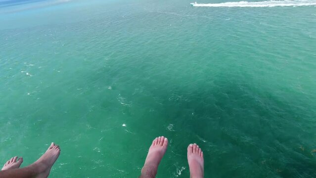 Parasail B Roll Of Feet Dangling In Sky From 2 People Parasailing With Green And Blue Ocean Water Below Them In The Florida Keys