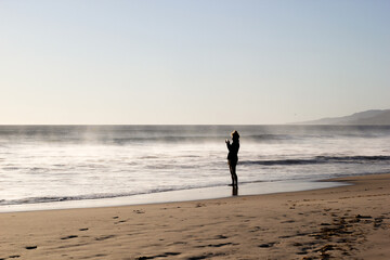person on the beach in backlight