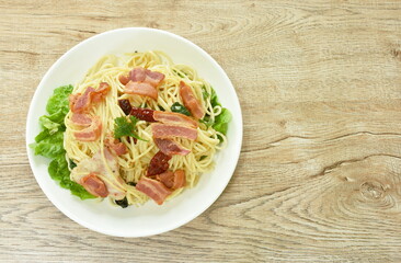 fried spaghetti topping crispy bacon and slice dry chili on plate  