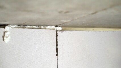 Worker with polyurethane foam and block. Close-up of a person applying polyurethane foam to a surface. The developer is foaming a gas block from a white block. 