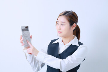計算機を持って計算する若い事務員